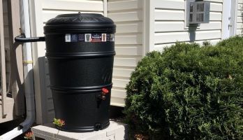 A rain barrel installed at a downspout